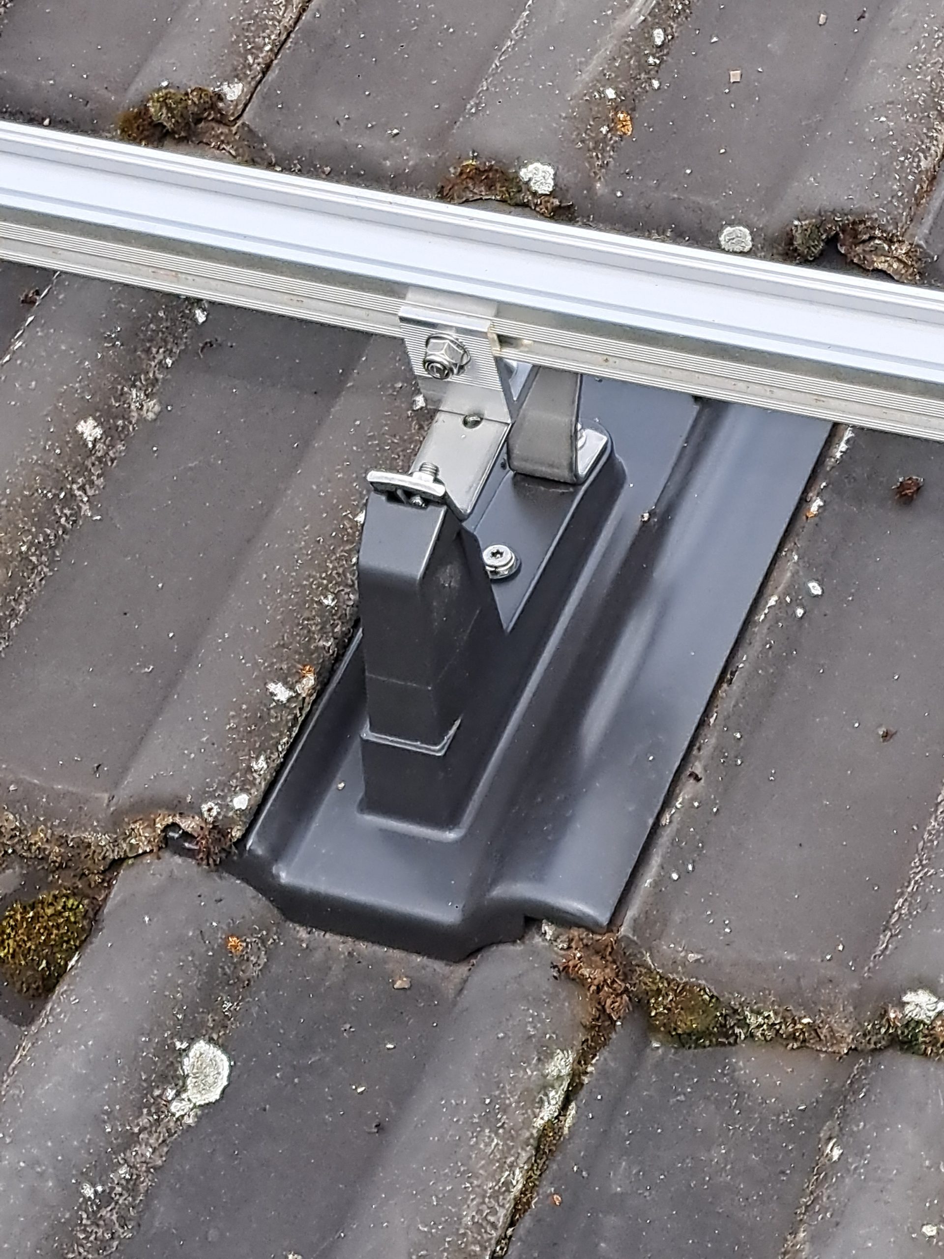 Detailaufnahme einer Montagehalterung für Solarmodule auf Ziegeldach